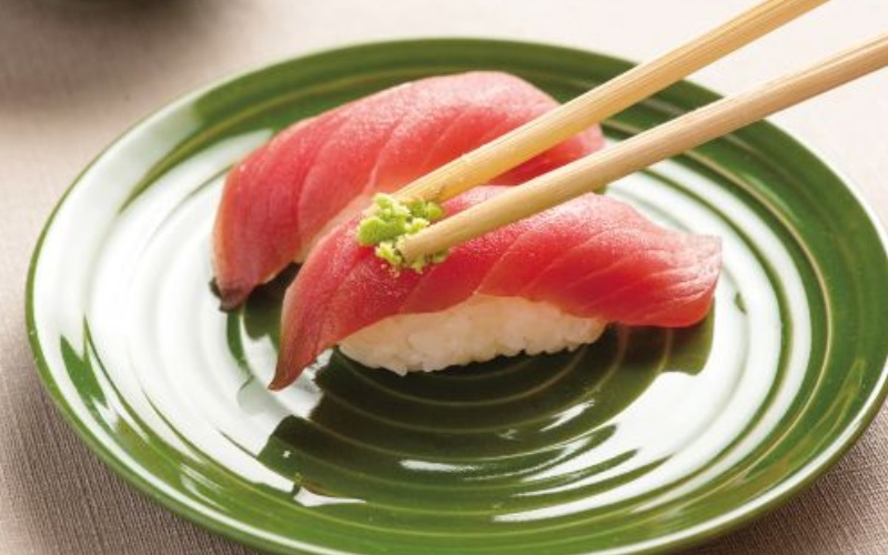 Dùng đũa phết một ít wasabi lên nhân sushi và chấm vào chén nước tương